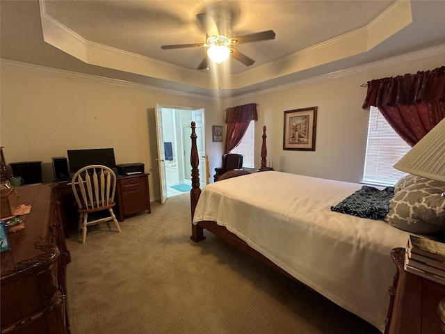 bedroom with crown molding, light colored carpet, and a tray ceiling