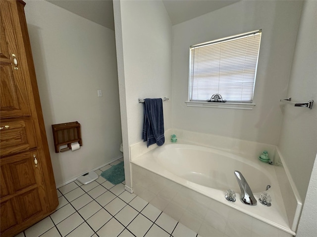 full bathroom featuring toilet, a bath, and tile patterned floors