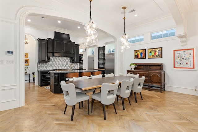 dining room with crown molding and light parquet floors