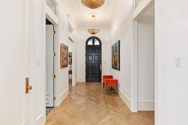 foyer with ornamental molding and light parquet floors