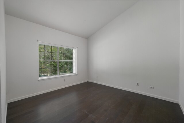 unfurnished room with dark wood-type flooring and vaulted ceiling