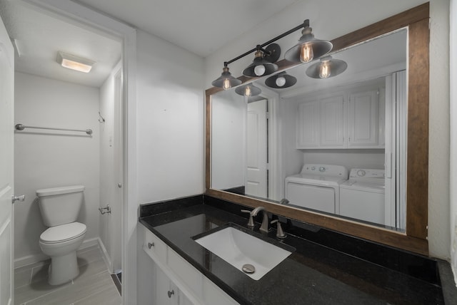 bathroom featuring washer and clothes dryer, vanity, and toilet