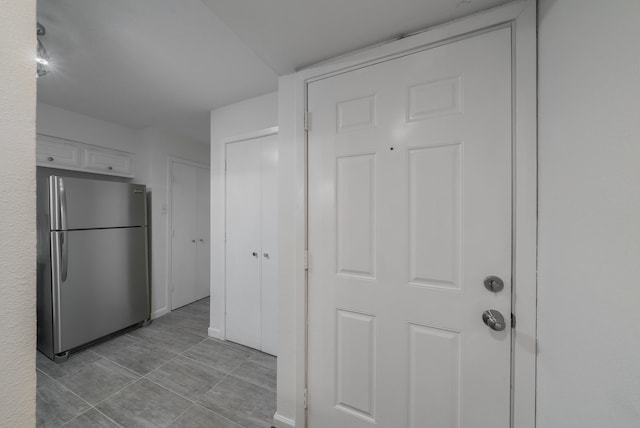 kitchen with white cabinetry and stainless steel refrigerator