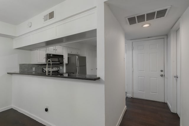 kitchen featuring dark hardwood / wood-style flooring, kitchen peninsula, decorative backsplash, white cabinets, and black appliances