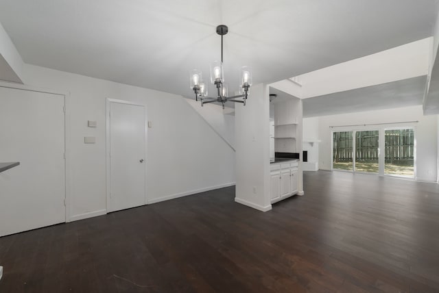 unfurnished living room with dark hardwood / wood-style flooring and an inviting chandelier