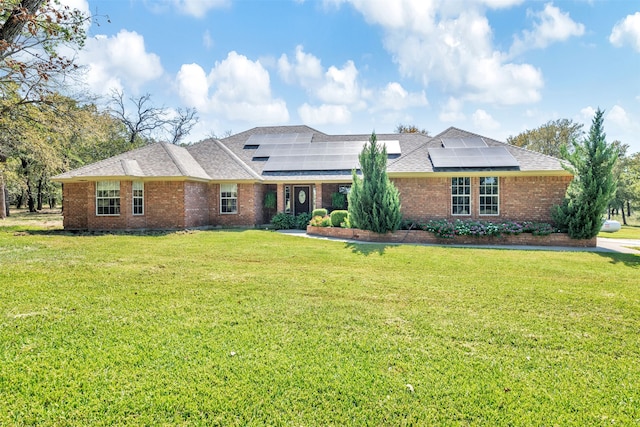 ranch-style house with solar panels and a front yard