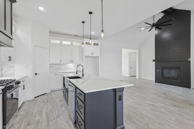 kitchen featuring white cabinets, hanging light fixtures, sink, a kitchen island with sink, and stainless steel appliances