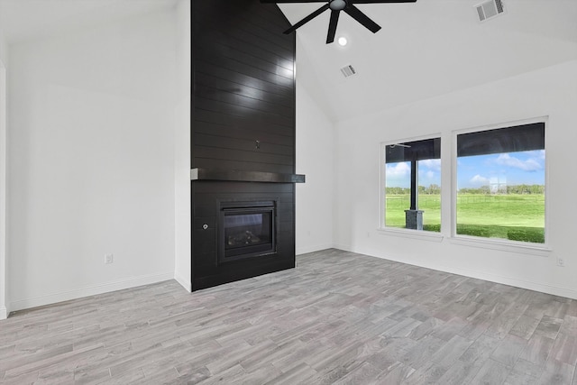 unfurnished living room featuring ceiling fan, a fireplace, high vaulted ceiling, and light hardwood / wood-style flooring