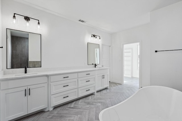 bathroom featuring parquet floors, a washtub, and vanity