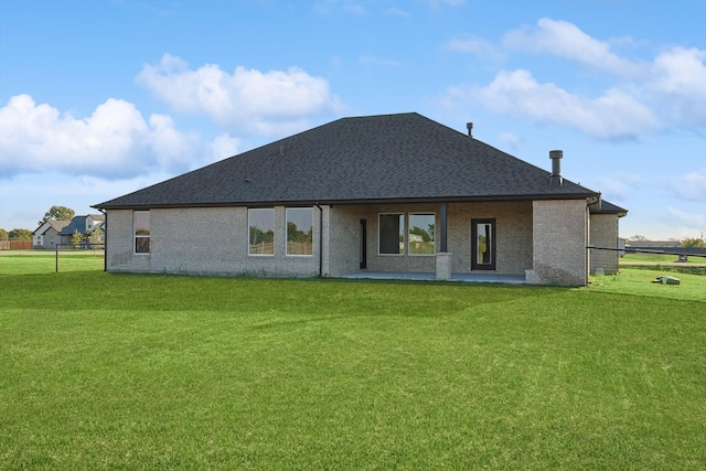 rear view of property featuring a patio and a lawn