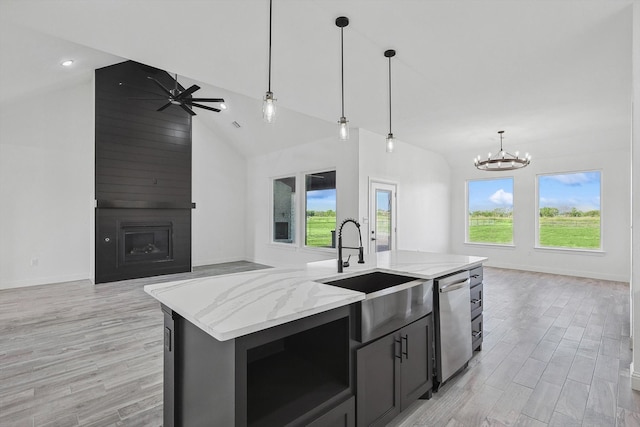 kitchen with dishwasher, decorative light fixtures, a center island with sink, and a wealth of natural light