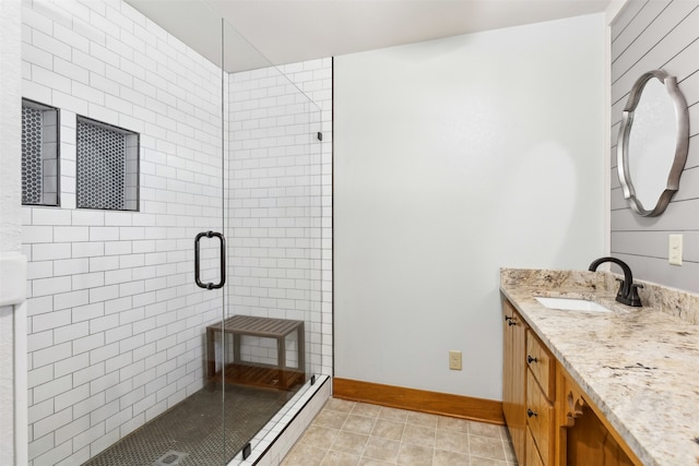 bathroom with tile patterned flooring, a shower with door, and vanity