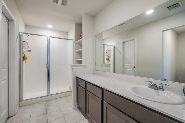 bathroom with tile patterned flooring, a shower with door, and vanity