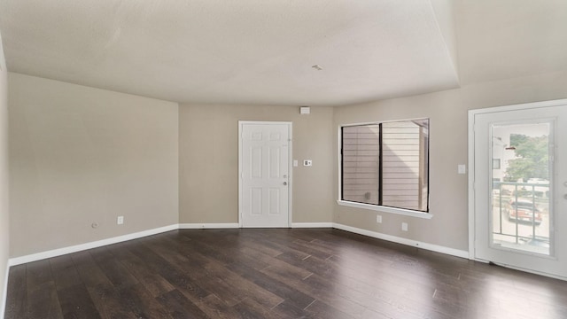 spare room featuring dark hardwood / wood-style floors and a textured ceiling