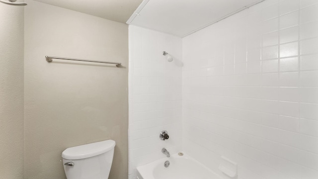 bathroom featuring tiled shower / bath and toilet