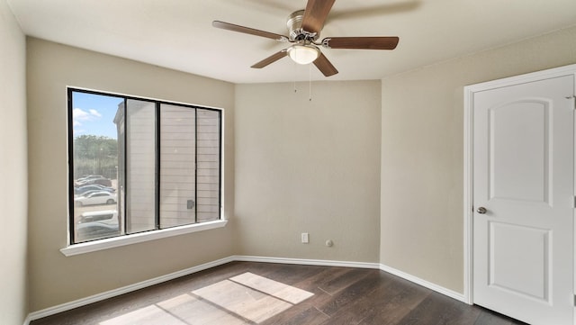 spare room featuring ceiling fan and dark wood-type flooring