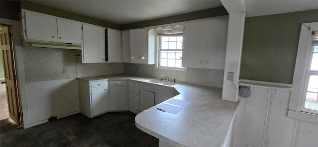 kitchen featuring extractor fan, white cabinetry, and sink