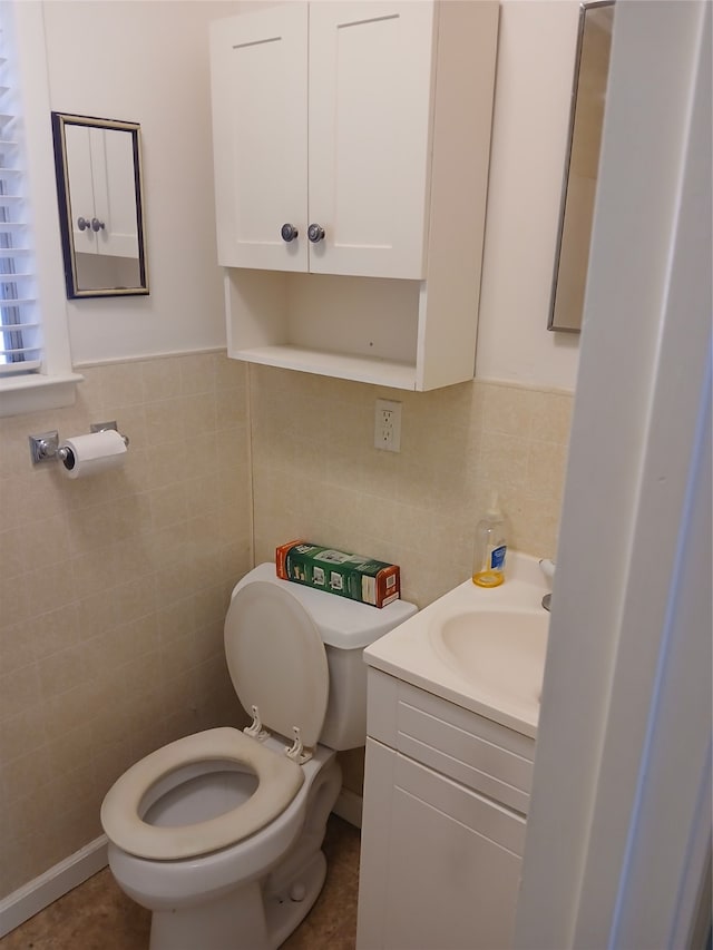 bathroom with vanity, tile walls, and toilet