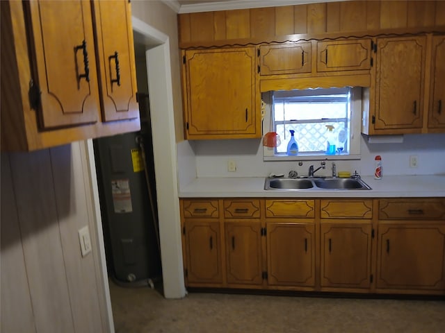 kitchen with electric water heater, crown molding, and sink