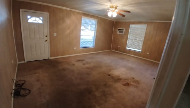 foyer entrance with an AC wall unit, carpet, wooden walls, and ceiling fan