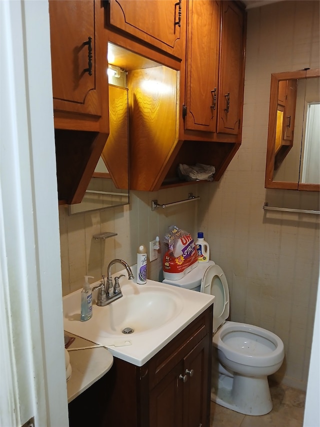 bathroom featuring vanity, backsplash, tile patterned floors, tile walls, and toilet