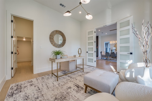 home office with built in shelves and light hardwood / wood-style floors