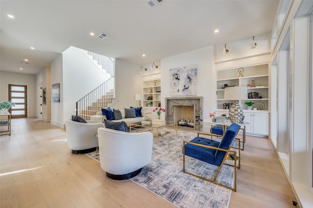 living room with built in features and light hardwood / wood-style flooring