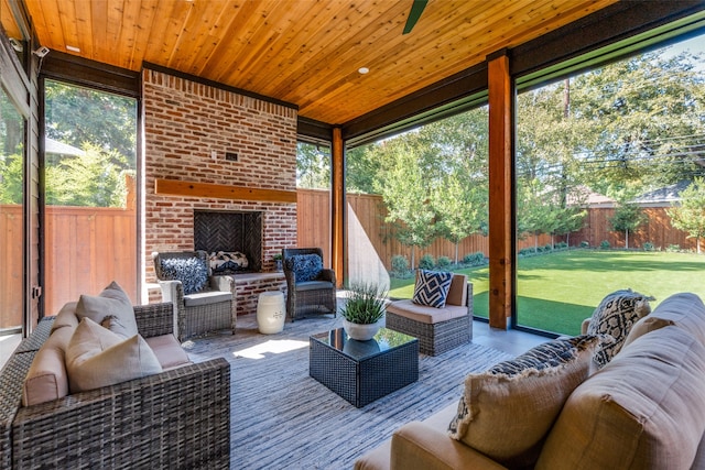 sunroom with an outdoor brick fireplace and wooden ceiling