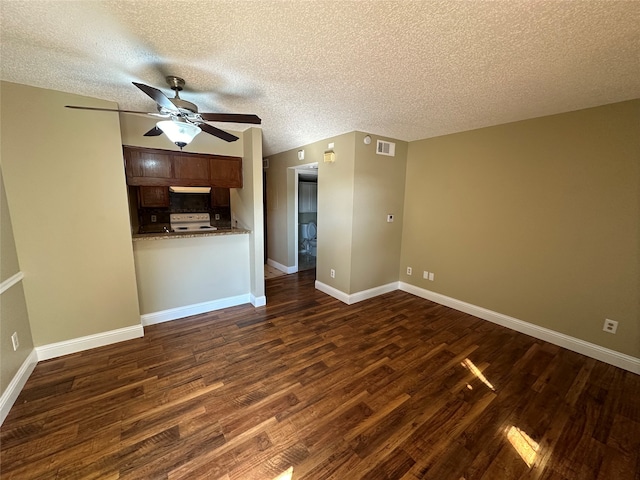 unfurnished living room with ceiling fan, dark hardwood / wood-style floors, and a textured ceiling