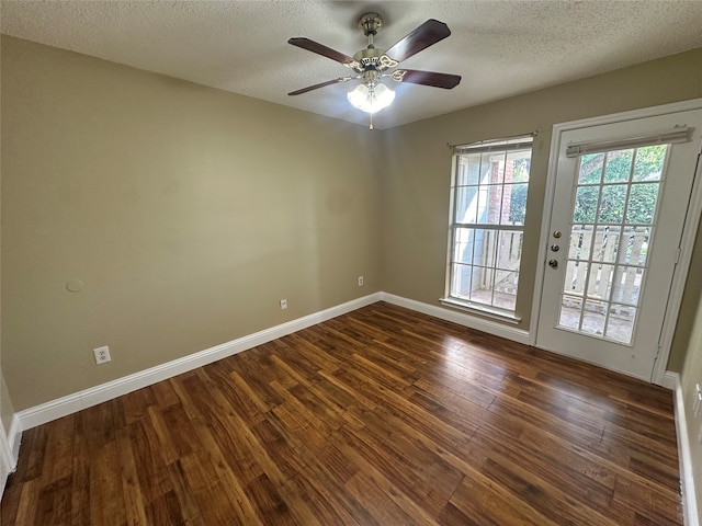 unfurnished room with ceiling fan, dark wood-type flooring, and a textured ceiling