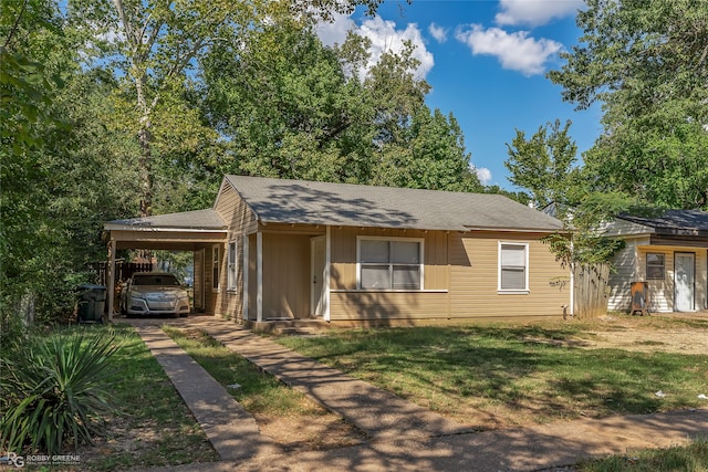 ranch-style home featuring a carport and a front yard