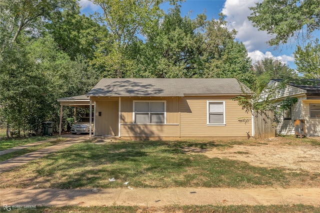 view of front facade with a front lawn and a carport