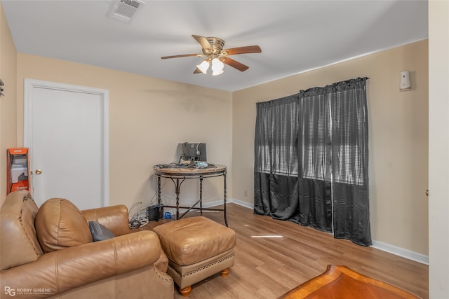 sitting room with wood-type flooring and ceiling fan