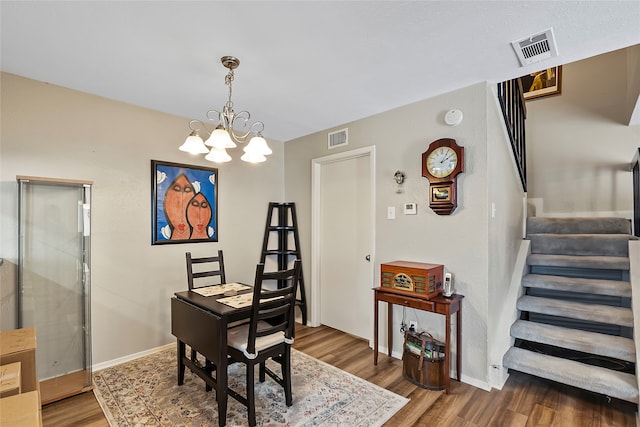 dining area featuring wood-type flooring and a notable chandelier