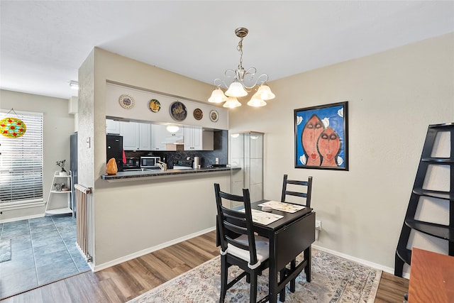 dining area with dark hardwood / wood-style floors and a chandelier