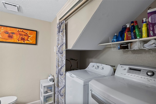 laundry room featuring a textured ceiling and independent washer and dryer