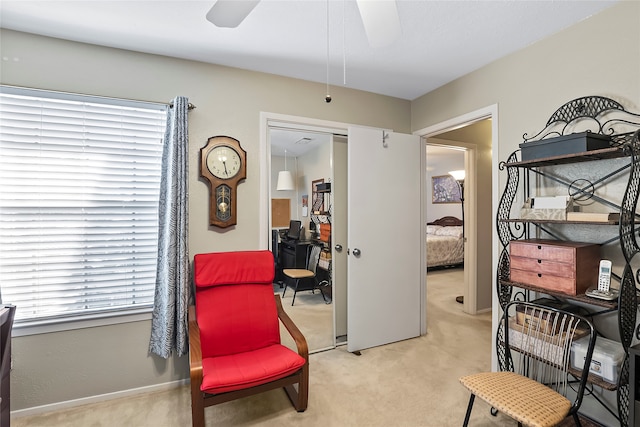 living area with ceiling fan and light carpet