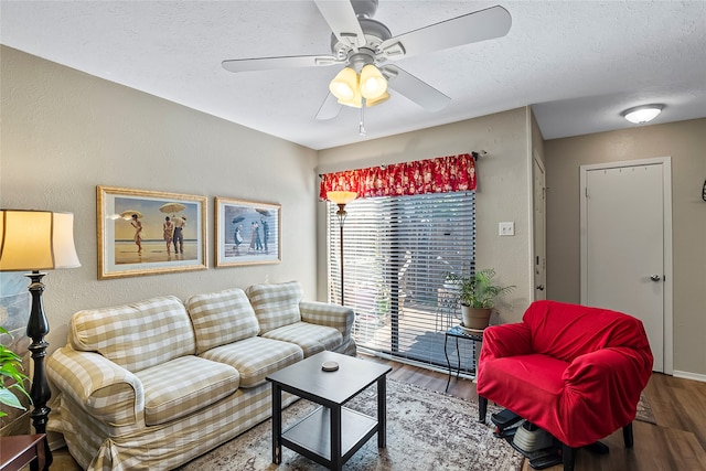 living room featuring hardwood / wood-style flooring, ceiling fan, and a textured ceiling