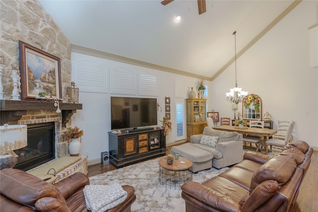 living room with high vaulted ceiling, a fireplace, hardwood / wood-style floors, and ceiling fan with notable chandelier