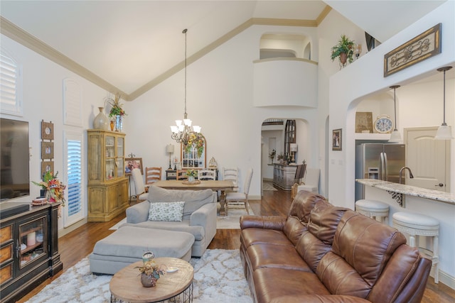 living room featuring a wealth of natural light, dark hardwood / wood-style flooring, high vaulted ceiling, and a notable chandelier