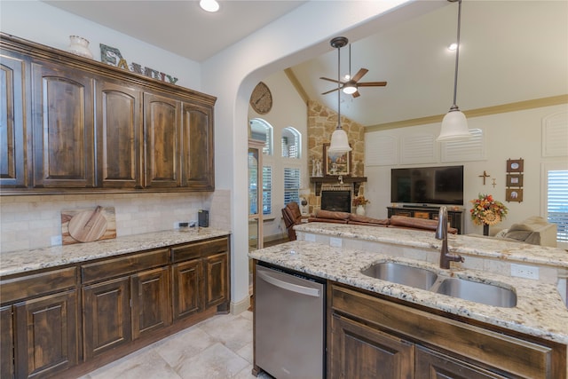 kitchen featuring sink, light stone counters, vaulted ceiling, dark brown cabinets, and dishwasher