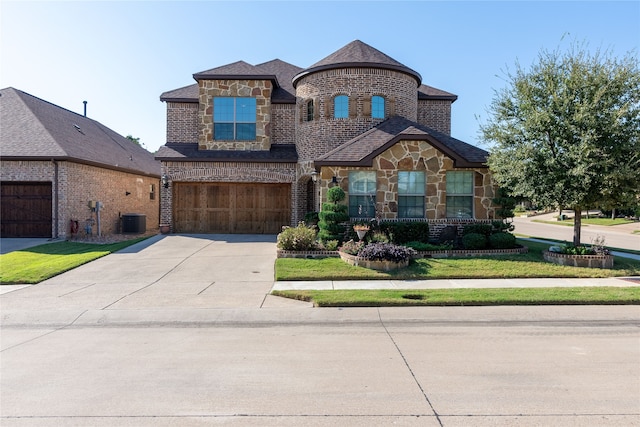 view of front of home featuring central AC unit, a garage, and a front yard