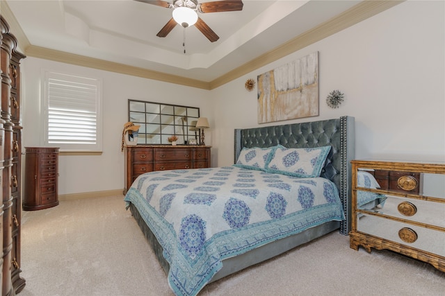 carpeted bedroom featuring ceiling fan, crown molding, and a tray ceiling