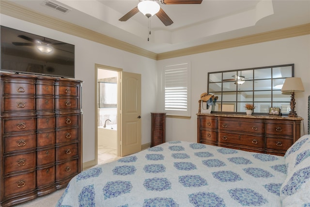 bedroom with light carpet, ceiling fan, ensuite bath, and a raised ceiling