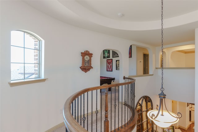 hall featuring a tray ceiling