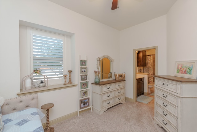 bedroom with ensuite bath, ceiling fan, and light colored carpet