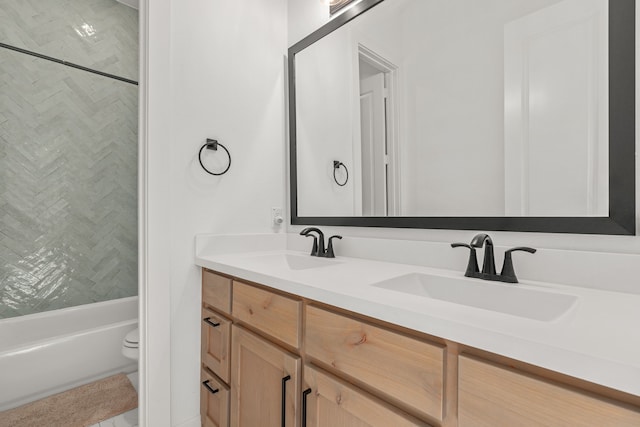 full bathroom featuring tiled shower / bath combo, vanity, and toilet