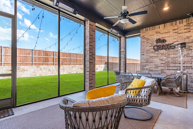 sunroom featuring ceiling fan and plenty of natural light