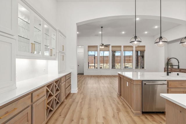 kitchen with ceiling fan, light hardwood / wood-style flooring, sink, dishwasher, and hanging light fixtures