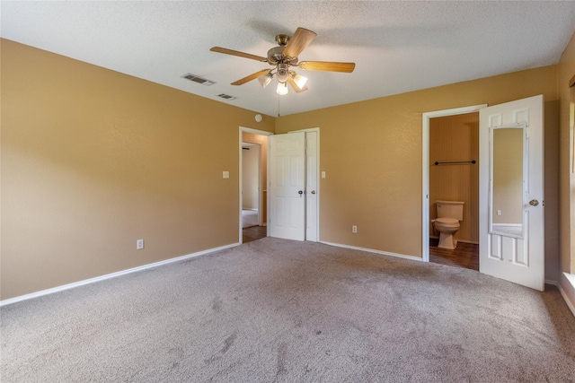 unfurnished bedroom featuring carpet flooring, ceiling fan, a closet, connected bathroom, and a textured ceiling